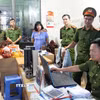 Lực lượng chức năng khám xét nơi làm việc của các bị can. (Ảnh: TTXVN phát)