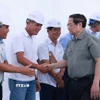 Thủ tướng Phạm Minh Chính với kỹ sư, công nhân thi công Dự án đường bộ cao tốc Châu Đốc-Cần Thơ-Sóc Trăng giai đoạn 1. (Ảnh: Dương Giang/TTXVN)