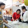 Đại diện doanh nghiệp Việt Nam giới thiệu sản phẩm bánh sầu riêng Việt Nam. (Ảnh: Công Tuyên/TTXVN)