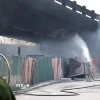Lực lượng Cảnh sát Phòng cháy chữa cháy nỗ lực kiểm soát đám cháy tại bãi trông giữ xe dưới gầm cầu Vĩnh Tuy. (Ảnh: Vũ Quang/TTXVN)