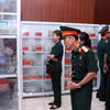 Các cựu chiến binh lặng lẽ trước tủ bày các di vật tìm thấy trong quá trình khai quật hài cốt liệt sỹ. (Ảnh: Xuân Khu/TTXVN)