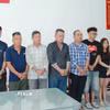 Nhóm 9 người liên quan trong vụ khiêng “quan tài” diễu phố tại Cơ quan điều tra. (Ảnh: TTXVN phát)