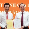 Bí thư Thành ủy Thành phố Hồ Chí Minh Nguyễn Văn Nên (bìa phải) trao Quyết định của Bộ Chính trị cho ông Nguyễn Mạnh Hùng. (Ảnh: Thanh Tân/TTXVN)