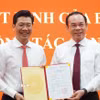 Bí thư Thành ủy Thành phố Hồ Chí Minh Nguyễn Văn Nên (bìa phải) trao Quyết định của Bộ Chính trị cho ông Nguyễn Mạnh Hùng. (Ảnh: Thanh Tân/TTXVN)