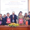 Tổng Giám đốc Thông tấn xã Việt Nam Vũ Việt Trang ký kết thỏa thuận hợp tác nghiệp vụ với Tổng Giám đốc Thông tấn xã Pathet Lào Vannasin Simmavong. (Ảnh: Văn Điệp/TTXVN)