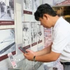 Du khách quét QR để tìm hiểu thông tin tại Nhà trưng bày thân thế, sự nghiệp Chủ tịch Tôn Đức Thắng, nằm trong Khu lưu niệm Chủ tịch Tôn Đức Thắng, thuộc xã Mỹ Hòa Hưng, tỉnh An Giang. (Ảnh: Công Mạo/TTXVN)