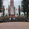 Đoàn cựu chiến binh phía Bắc chụp ảnh kỷ niệm tại Đài tưởng niệm Đăk Tô. (Nguồn: Vietnam+)