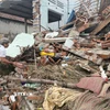 Người dân dọn dẹp nhà cửa bị sập do mưa lũ gây ra. (Ảnh: Tường Quân/TTXVN)