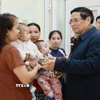 Thủ tướng Phạm Minh Chính với nhân dân đến khám, chữa bệnh tại trạm y tế xã Yên Khương. (Ảnh: Dương Giang/TTXVN)