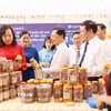 Lãnh đạo tỉnh Đồng Nai tham quan gian hàng đặc sản hạt điều rang muối của địa phương. (Ảnh: Nhật Bình/TTXVN)