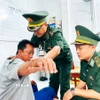 Quân y Đồn Biên phòng Gành Hào chăm sóc sức khỏe cho thuyền viên gặp nạn. (Ảnh: TTXVN phát)