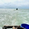 Lai dắt tàu cá gặp nạn vào bờ. (Ảnh minh họa: TTXVN phát)