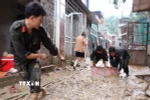 Các chiến sỹ đồn biên phòng Cửa khẩu Quốc tế Thanh Thủy (Tuyên Quang) giúp người dân dọn vệ sinh sau lũ. (Ảnh: Đức Thọ/TTXVN)