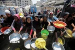 Người dân chờ được phát thực phẩm cứu trợ tại Gaza. (Ảnh: THX/TTXVN)