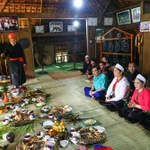 Trong lễ cúng vía bếp của người Mường, con cháu trong nhà ngồi quây quần thực hiện nghi lễ. (Ảnh: Hải Ly/TTXVN)