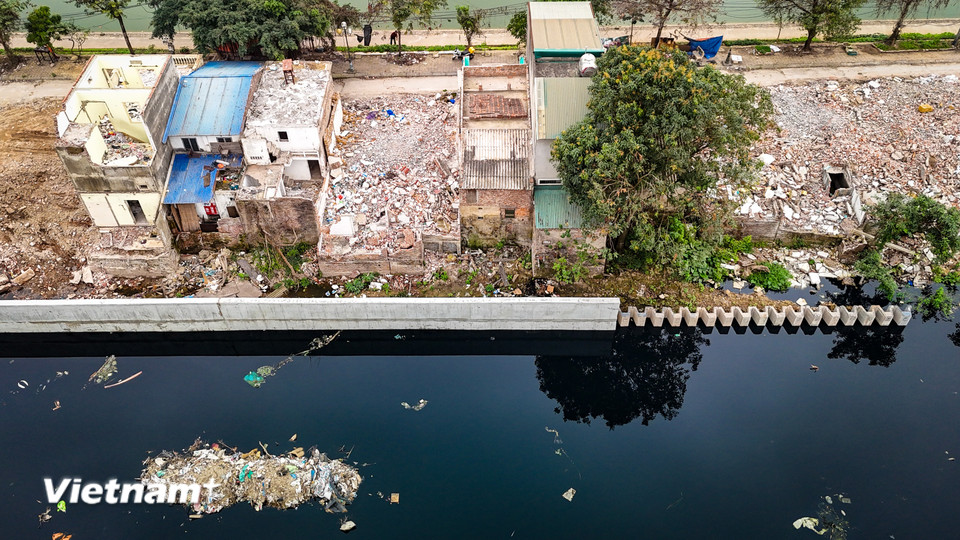 Theo ghi nhận của phóng viên, nhiều đoạn đường dọc hai bên kênh dẫn hiện ngổn ngang rác thải, vật liệu xây dựng. (Ảnh: Hoài Nam/Vietnam+)
