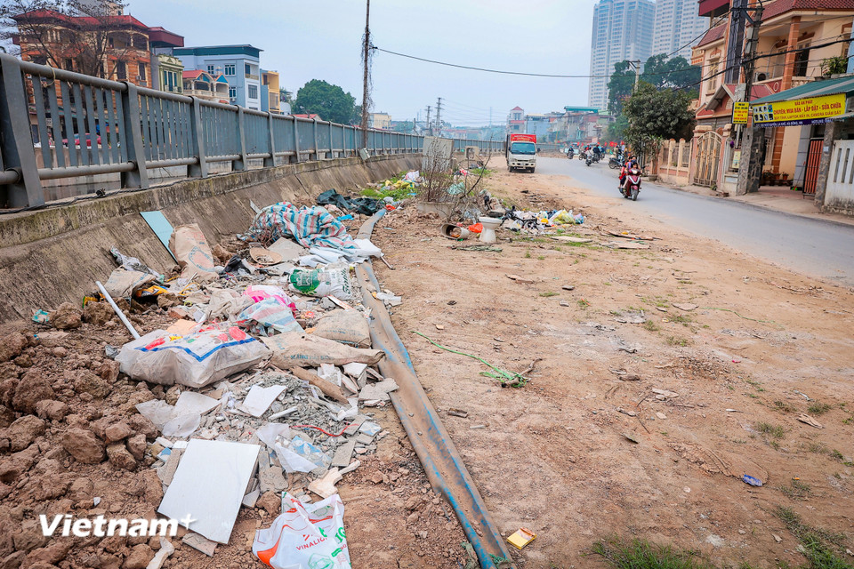 Chị Hà Phương (La Khê, Hà Đông, Hà Nội) hằng ngày đi làm qua đoạn đường này chia sẻ: “Dòng nước quanh năm đen kịt, bốc mùi hôi thối nồng nặc rất khó chịu nhất là vào những ngày nắng. Chỉ mong dự án sớm hoàn thành để người dân sinh sống tại đây đỡ khổ.” (Ảnh: Hoài Nam/Vietnam+)