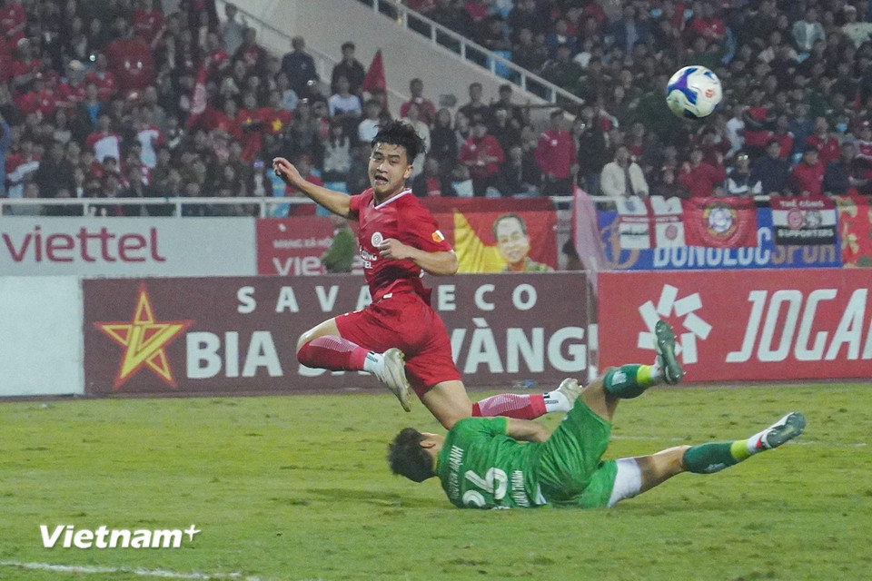 Tiền vệ Danh Trung không thể chiến thắng thủ môn Nguyên Mạnh trong pha đối mặt. Sau tình huống này, "người gác đền" của Nam Định phải rời sân vì chấn thương. (Ảnh: Việt Anh/Vietnam+)