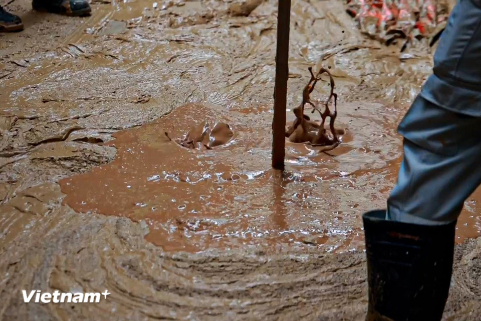 Chỉ sau thời gian ngắn bùn đã tràn kín ngõ, có vị trí ngập sâu tới 30cm vào nhà. (Ảnh: Minh Hiếu/Vietnam+)