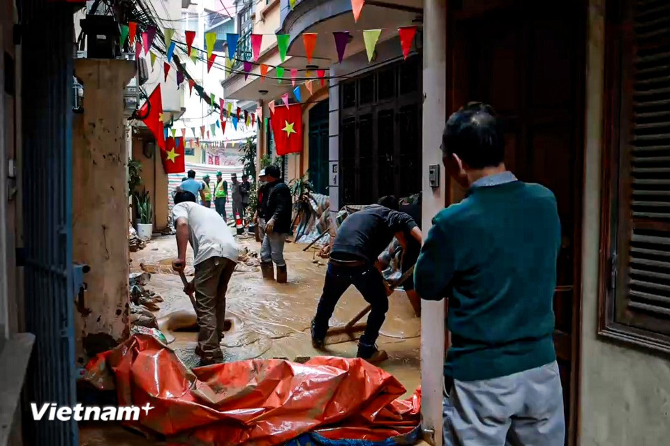 Người dân và công nhân được huy động nhằm khắc phục sự cố tràn bùn. (Ảnh: Minh Hiếu/Vietnam+)