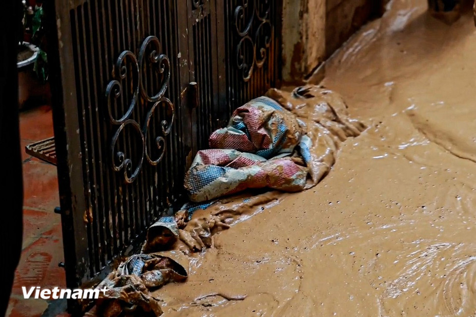 Các hộ gia đình phải sử dụng bạt bao tải chắn để ngăn bùn đất vào trong nhà. (Ảnh: Minh Hiếu/Vietnam+)