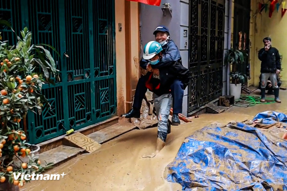 Người dân di chuyển khó khăn do bùn đất "phủ kín" con ngõ. (Ảnh: Minh Hiếu/Vietnam+)