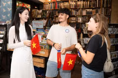 Du khách quốc tế được tặng cờ đỏ sao vàng khi du lịch Thành phố Hồ Chí Minh. (Ảnh: CTV/Vietnam+)
