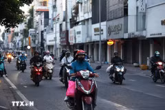 Người dân trong trang phục giữ ấm đi làm trên đường Hồ Văn Huê (phường Đức Nhuận) thời điểm 6 giờ 20 phút sáng 9/1/2026. (Ảnh: Hồng Đạt/TTXVN)
