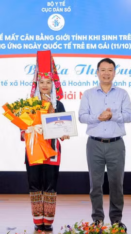 Ông Lê Thanh Dũng - Cục trưởng Cục Dân số trao Giải Nhất cá nhân cho bà La Thị Huệ - Trạm Y tế xã Hoành Mô, thành phố Quảng Ninh (Ảnh: PV/Vietnam+)