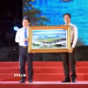 Phó Chủ tịch Thường trực UBND tỉnh Khánh Hòa Nguyễn Long Biên (bên phải) tặng quà lưu niệm đến lãnh đạo UBND tỉnh Quảng Trị. (Ảnh: Tá Chuyên/TTXVN)