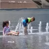 Trẻ em giải nhiệt tránh nóng tại một đài phun nước. (Ảnh: THX/TTXVN)
