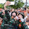 Các nữ chiến sỹ thông tin chụp ảnh kỷ niệm với người dân Hà Nội trước giờ tổng hợp luyện sự kiện A80. (Ảnh: Hoàng Hà/TTXVN)