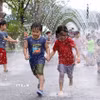 Các em nhỏ chơi đùa bên đài phun nước để tránh nóng tại Seoul, Hàn Quốc. (Ảnh: THX/TTXVN)