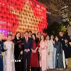 Cán bộ Tổng lãnh sự quán Việt Nam tại Perth chụp ảnh lưu niệm với hình ảnh Quốc kỳ Việt Nam được thắp sáng trên Tòa thị chính Perth. (Ảnh: TTXVN phát)