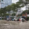 Người dân di chuyển qua khu vực ngập úng. (Ảnh: Huy Hùng/TTXVN)