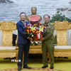 Đại sứ Việt Nam tại Lào Nguyễn Minh Tâm tặng hoa chúc mừng Bộ Công an Lào nhân dịp Kỷ niệm 50 năm Quốc khánh Lào và 105 Ngày sinh Chủ tịch Kaysone Phonvihane. (Ảnh: Xuân Tú/TTXVN)