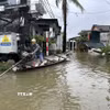 Mưa lớn gây ngập khiến người dân phải di chuyển bằng ghe. (Ảnh: Mai Trang/TTXVN)