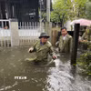 Bí thư Đảng ủy xã Núi Thành Nguyễn Như Công và các thành viên đến từng khu dân cư bị ngập nước để vận động nhân dân di chuyển đến nơi an toàn. (Ảnh: Đoàn Hữu Trung/TTXVN)