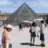Du khách tham quan Bảo tàng Louvre ở Paris, Pháp dưới trời nắng gay gắt. (Ảnh: THX/TTXVN phát)