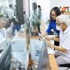 Đội thanh niên tình nguyện hỗ trợ vận hành chính quyền 2 cấp và cung cấp dịch vụ công trực tuyến tại Trung tâm Phục vụ hành chính công phường Cầu Giấy, Hà Nội. (Ảnh: Minh Đức/TTXVN)