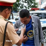 Lực lượng chức năng kiểm tra nồng độ cồn. (Nguồn: TTXVN)