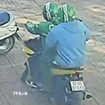 Các đối tượng dùng súng cướp ngân hàng. (Ảnh chụp màn hình camera. TTXVN phát)