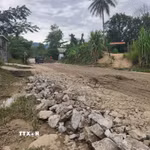 Người dân hàng ngày phải đi qua tuyến đường đầy bùn đất, đá hộc. (Ảnh: Quốc Dũng/TTXVN)