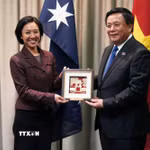 GS.TS Nguyễn Xuân Thắng tặng quà lưu niệm cho đại diện Trường Quản trị Australia và New Zealand. (Ảnh: Diệu Linh/TTXVN)