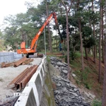 Đơn vị thi công đóng cọc ván thép để gia cố tạm thời mặt đường chống sạt lở trên đèo Prenn. (Ảnh: Chu Quốc Hùng/TTXVN)