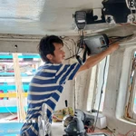 Ngư dân xã Long Hải, Thành phố Hồ Chí Minh, kiểm tra thiết bị giám sát hành trình trước khi ra khơi xuất bến. (Ảnh: Hoàng Nhị/TTXVN)