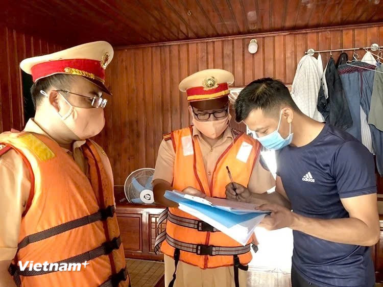 Lực lượng Cảnh sát giao thông đường thủy hướng dẫn các chủ phương tiện ký cam kết chấp hành nghiêm Luật Giao thông đường thủy. (Ảnh: Nguyễn Thảo/Vietnam+)