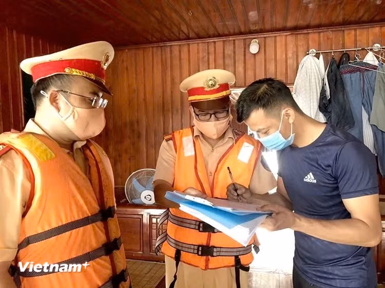 Lực lượng Cảnh sát giao thông đường thủy hướng dẫn các chủ phương tiện ký cam kết chấp hành nghiêm quy định. (Ảnh: Nguyễn Thảo/Vietnam+)