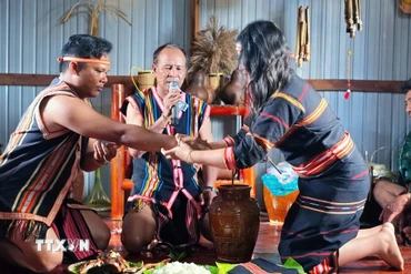 Nghi thức đeo vòng đồng đính ước - thể hiện lời ước hẹn bền chặt của đôi trai gái tại Lễ cầu hôn (Lễ ăn hỏi) của người Jrai tại tỉnh Gia Lai. (Ảnh: Hồng Điệp/TTXVN)