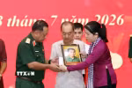 Phút nghẹn ngào của thân nhân liệt sỹ đón nhận di ảnh liệt sỹ đã được phục dựng. (Ảnh: Xuân Khu/TTXVN)